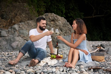 happy young couple having picnic on beach
