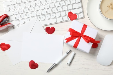 Flat lay composition with blank card on white wooden table, space for text. Valentine's Day celebration