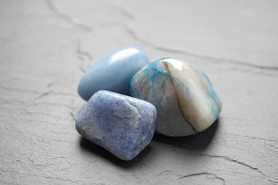 Photo of Beautiful natural blue gemstones on grey table
