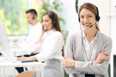 Young female receptionist with headset in office
