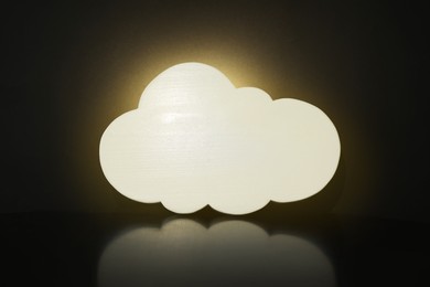 Cloud shaped glowing night lamp on black background