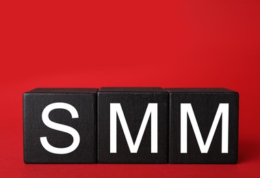 Black cubes with abbreviation SMM (Social media marketing) on red background