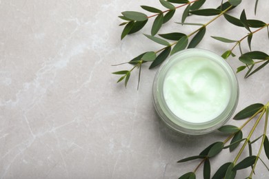 Photo of Jar of organic cream and eucalyptus on light marble table, flat lay. Space for text