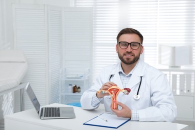 Gynecologist demonstrating model of female reproductive system in clinic