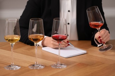 Sommelier tasting different sorts of wine at table indoors, closeup