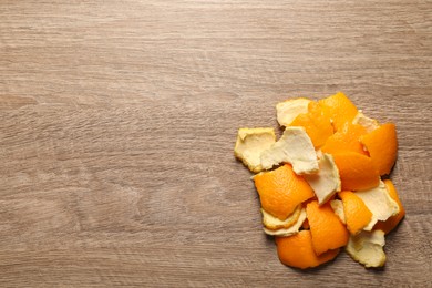 Photo of Orange peels preparing for drying on wooden table, flat lay. Space for text