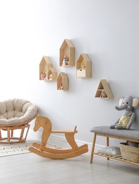 House shaped shelves and rocking horse in children's room. Interior design