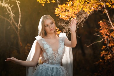 Beautiful girl wearing fairy dress in autumn forest
