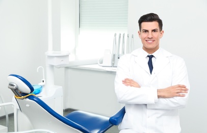 Portrait of professional male dentist in clinic. Space for text