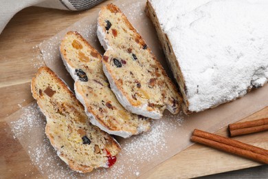 Traditional Christmas Stollen with icing sugar on wooden board, top view
