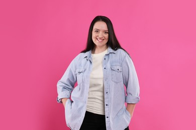 Beautiful overweight woman with charming smile on pink background