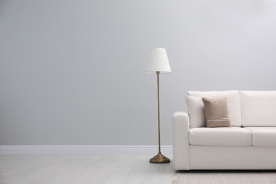 Simple room interior with comfortable white sofa, space for text
