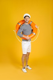 Happy sailor with orange ring buoy on yellow background