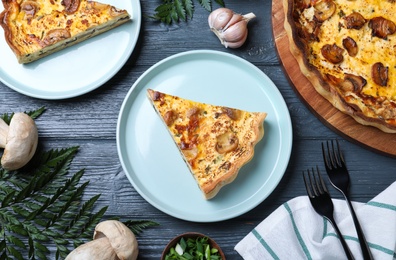 Delicious pie with mushrooms and cheese served on grey wooden table, flat lay