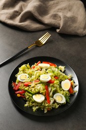 Delicious salad with Chinese cabbage and quail eggs served on black table