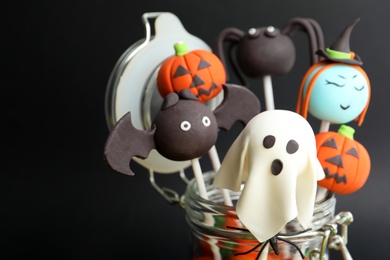 Delicious Halloween themed cake pops on black background, closeup