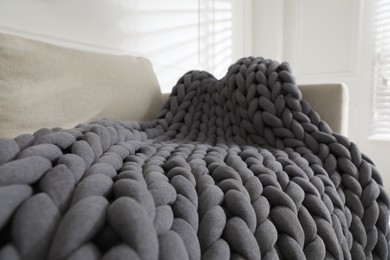 Soft chunky knit blanket on sofa in room, closeup
