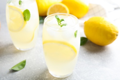 Glasses of cold lemonade on grey table, closeup