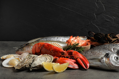 Fresh fish and different seafood on grey table
