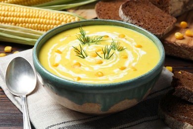 Delicious creamy corn soup served on wooden table
