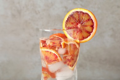 Delicious refreshing drink with sicilian orange on beige background, closeup