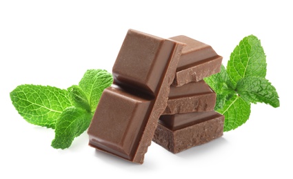 Tasty milk chocolate pieces and mint on white background