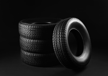Set of winter tires on black background