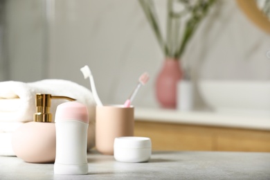 Stick deodorant and different toiletry on table in bathroom, space for text