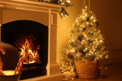 Beautiful Christmas tree near fireplace in room