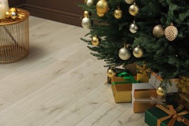 Beautifully decorated Christmas tree and many gift boxes in room, closeup. Space for text