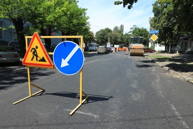 Barricade with traffic signs on city street. Road repair