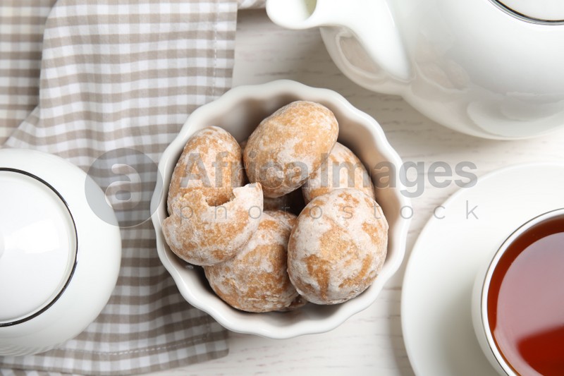 Photo of Tasty homemade gingerbread cookies and tea on white wooden table, flat lay