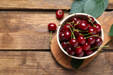 Sweet juicy cherries on wooden table, flat lay. Space for text