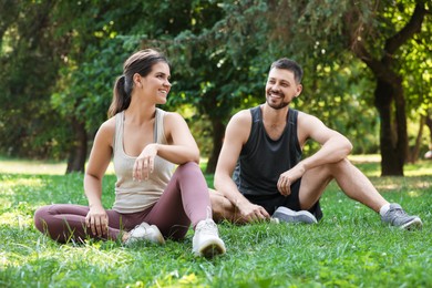 Man and woman resting after morning exercise in park