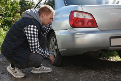 Photo of Stressed man near car with scratch outdoors