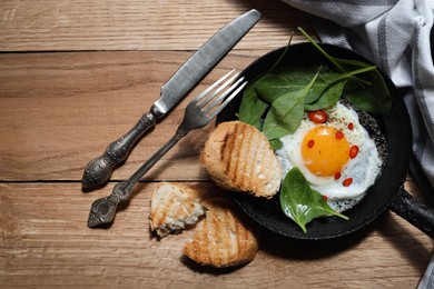 Photo of Delicious fried egg with spinach and chilli served on wooden table, flat lay