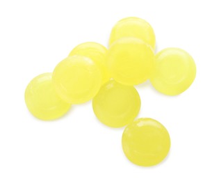 Many yellow cough drops on white background, top view