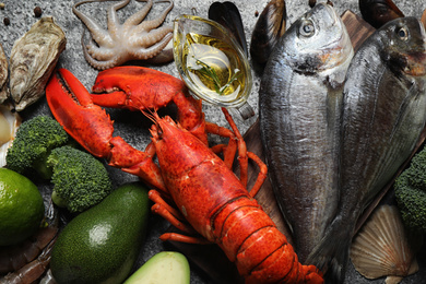 Photo of Fresh fish and different seafood on grey table, top view