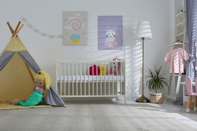 Baby room interior with cute posters, play tent and comfortable crib