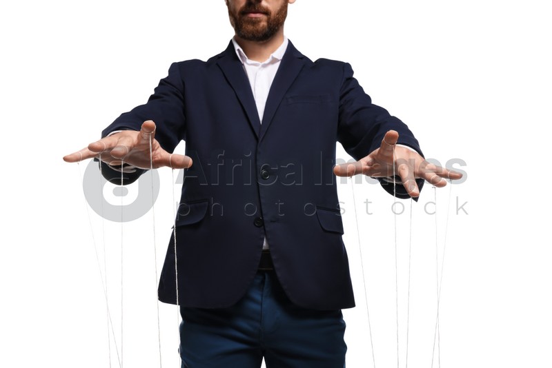 Man in suit pulling strings of puppet on white background, closeup
