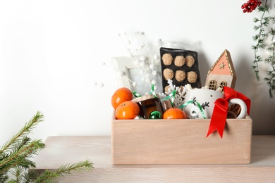 Crate with gift set and Christmas decor on wooden table