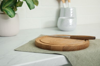 Clean towel, wooden cutting board and knife on countertop in kitchen