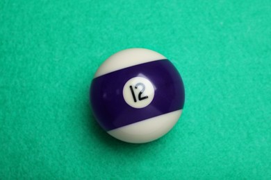 Billiard ball with number 12 on green table, top view