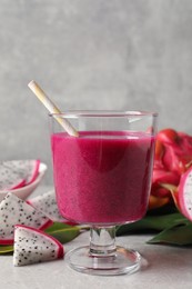 Delicious pitahaya smoothie and fresh fruits on light grey table