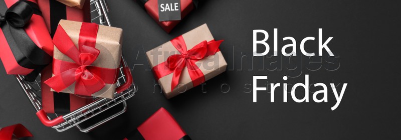 Cart with gift boxes on dark background, flat lay. Black Friday sale