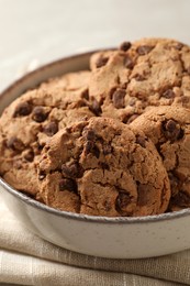 Delicious chocolate chip cookies in bowl on table, closeup