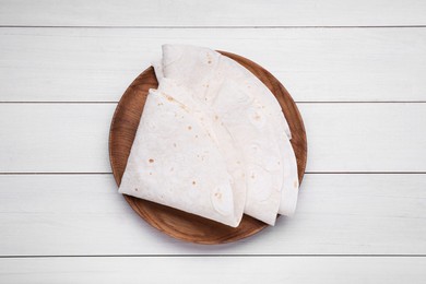 Photo of Delicious folded Armenian lavash on white wooden table, top view