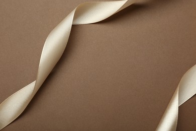 Beautiful ribbons on brown background, flat lay. Space for text