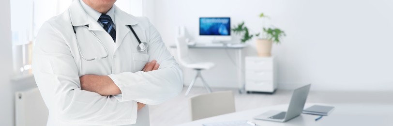 Doctor in uniform at workplace in clinic, space for text. Banner design