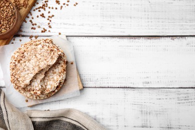 Crunchy buckwheat cakes on white wooden table, flat lay. Space for text